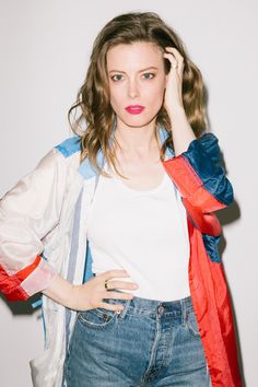 a woman in jeans and a white t - shirt is holding her hand on her head