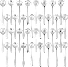 many spoons and forks are lined up in the shape of flower petals with long tails