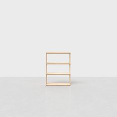 an empty wooden shelf sitting on top of a white floor