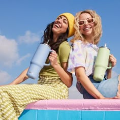 two women sitting on top of a pink and blue float