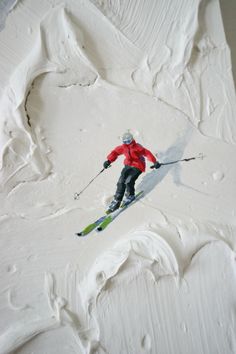 a man riding skis down the side of a snow covered slope with white frosting