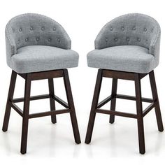 two gray upholstered barstools with buttons on the backrests and arms