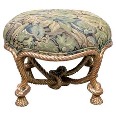 an ornate foot stool with rope wrapped around the bottom and upholstered in floral fabric