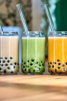 three glasses filled with different types of smoothies