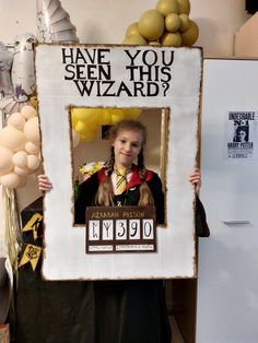 a woman holding up a photo frame with the words have you seen this wizard?