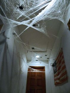 a hallway decorated for halloween with spider webs on the ceiling