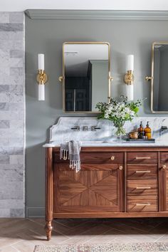 a bathroom with two sinks and mirrors on the wall