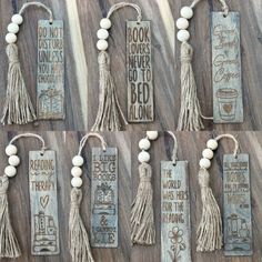 eight bookmarks with tassels and beads hanging on a wooden table next to each other