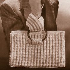 an old photo of a woman holding a purse with her hand on her face and looking at the camera