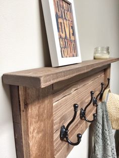 a wooden shelf with coat hooks and a card holder on the top that says you are loved