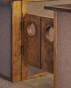 an office cubicle with two speakers in the center and one door open to reveal another room