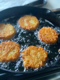 some fried food cooking in a frying pan on top of a stove burner