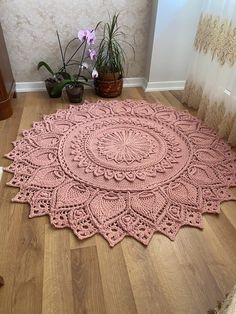 a pink rug on the floor next to potted plants