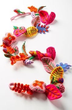 several colorful hair clips are arranged on a white surface and one is shaped like a butterfly