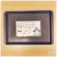 a tray with some buttons on it and a snowman in the middle that says four