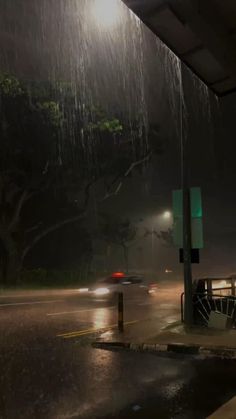 a car driving down a rain soaked street at night