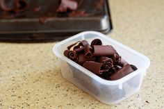 a plastic container filled with chocolate pieces on top of a counter