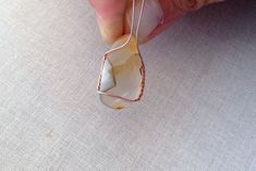 a person is holding a wire wrapped pendant