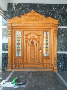 a room that has some kind of wooden door in the middle of it with marble walls and flooring