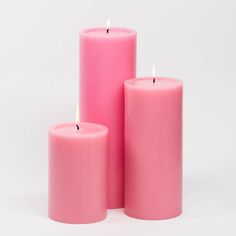 three pink candles sitting next to each other