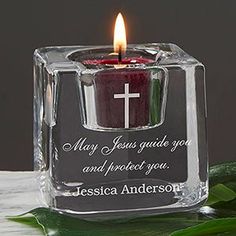 a small glass candle holder with a cross on it and the words may jesus guide you and protect you