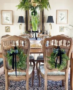 the dining room table is decorated with wreaths and greenery