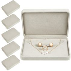 four pieces of jewelry in a white box with gold and pearl beads on the necklace