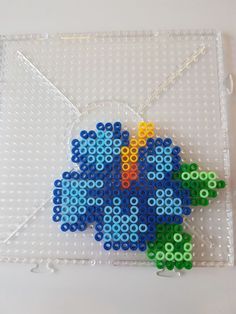 an envelope made out of legos with a blue flower on the front and green flowers on the back