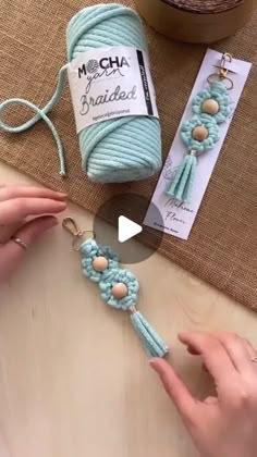 a person is making something with yarn and beads on the table next to some other items