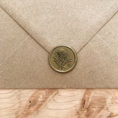 an envelope with a wax stamp on it sitting on top of a piece of wood