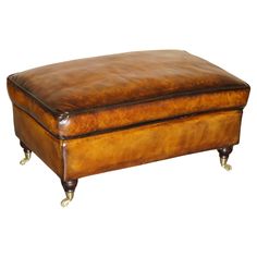 a brown leather ottoman sitting on wheels