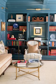 a living room with bookshelves, couch and coffee table in front of it