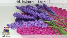 purple crocheted flowers sitting on top of a pink doily next to each other