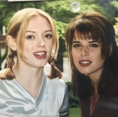 two women are looking at the camera and smiling