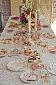 the table is set with pink and white china