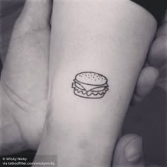 a small hamburger tattoo on the left inner arm