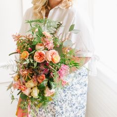 a woman holding a bouquet of flowers in her hands