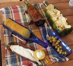 corn on the cob, beans and other foods are sitting on a table