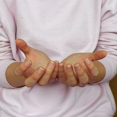 a person holding their hands together in front of the camera with both hands folded out