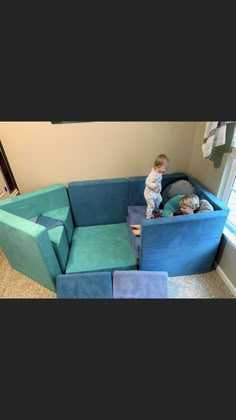 a small child standing on top of a blue couch