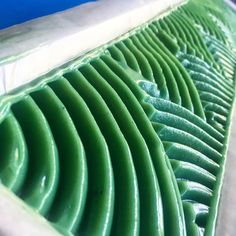 close up view of the inside of a green piece of plastic material with wavy lines