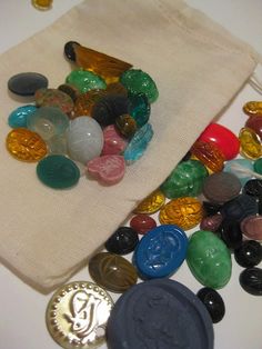 a bag filled with lots of different colored stones and coins next to a coin purse