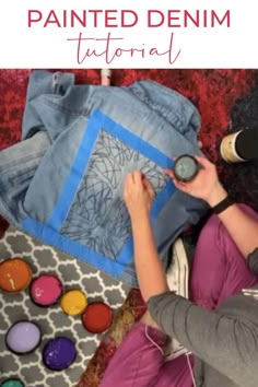 a woman sitting on the floor next to some fabric and sewing supplies with text overlay that reads, how to paint denim