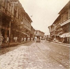 an old black and white photo of people walking down the street in front of buildings