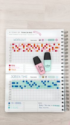 a planner with two pens on top of it and an exercise tracker next to it