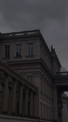 an old building with columns under a cloudy sky