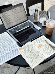 an open laptop computer sitting on top of a table next to a cup of coffee