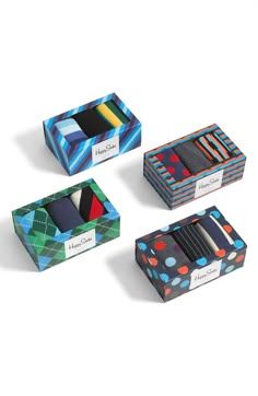 three boxes with ties in them on a white surface and one box has four different colors