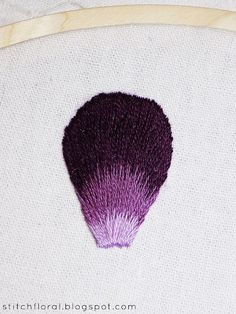 a close up of a purple brush on a white cloth