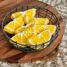 corn on the cob with white icing in a wire basket next to a cutting board